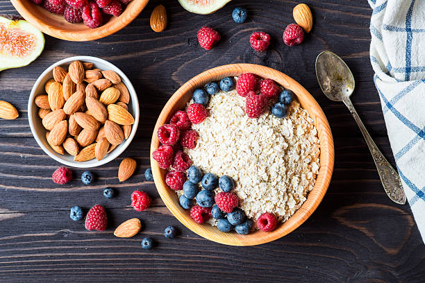 Healthy Breakfast. Bowl of muesli with berries and nuts over dark wooden background. Health and diet concept.