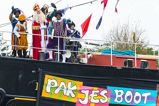 Sinterklaas arriving in The Netherlands with his steamboat Meppel, The Netherlands - November 14, 2015: The arrival of Sinterklaas in the city of Meppel on the steam boat Pakjesboot 12 coming from Spain. Sinterklaas is standing on the boat's bow surrounded by his helpers the  Black Petes. The arrival in Meppel is the official arrival of Sinterklaas in The Netherlands for 2015 and is broadcasted on national television. Sinterklaas is a traditional Dutch holiday for children that is celebrated on the 5th of December. zwarte piet stock pictures, royalty-free photos & images