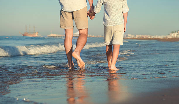 istock Father and son legs on sea surfline image 497002832