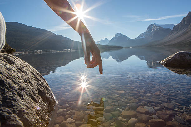 istock Finger touches surface of mountain lake 497004534