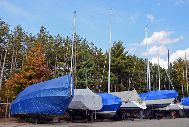 covered boats in outdoor storage stock photo