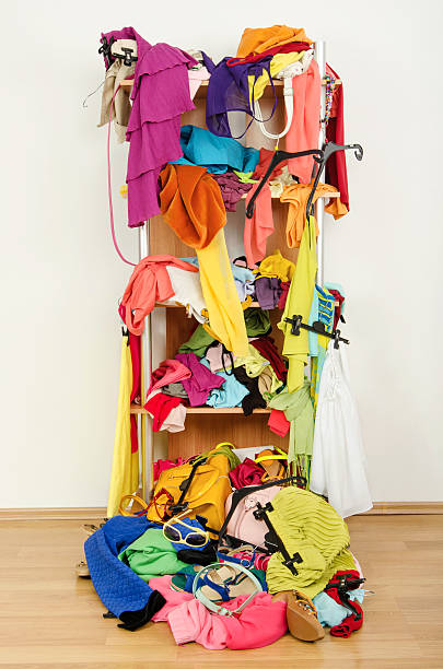istock Untidy cluttered wardrobe with clothes falling out of a shelf. 497008035