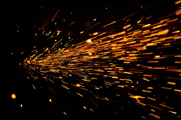Glowing Flow of Sparks in the Dark Glowing sparks coming from a grinder in the dark grind stock pictures, royalty-free photos & images