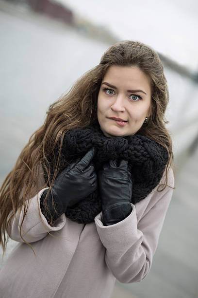 Lovely woman in coat and gloves, bit her lip stock photo