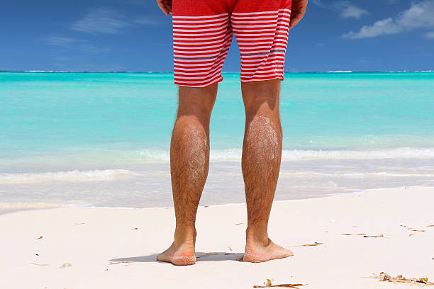 homme debout sur la plage - shorts rear view summer beach photos et images de collection