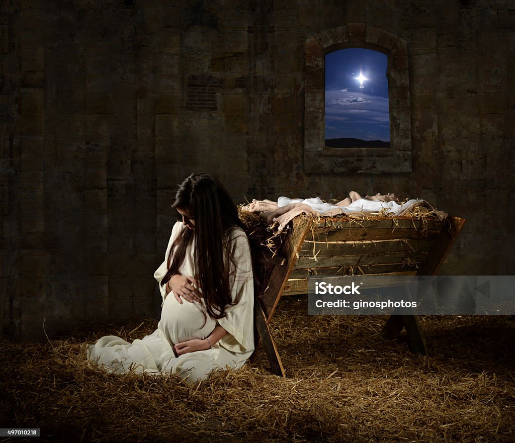 Pregnant Mary Leaning on Manger Young pregnant Mary praying leaning on manger on Christmas Eve Virgin Mary Stock Photo