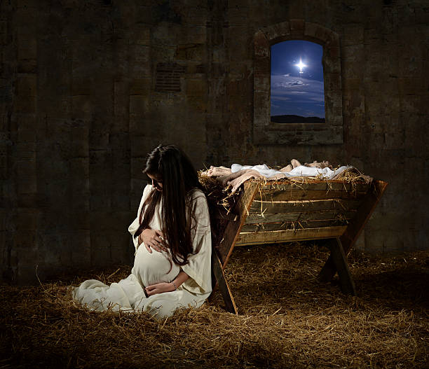pregnant mary leaning on manger - madonna stok fotoğraflar ve resimler