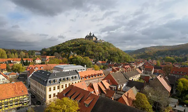 A top view over Wernigerode town with a medievel castle crowning the hill top. Wide angle picture taken from the top of a town church on a cloudy Autumn dayA top view over Wernigerode town in Germany