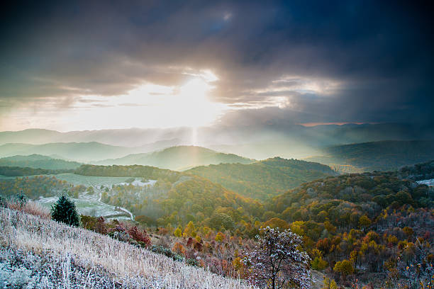 Mountain sunrise autumn with winter snow Mountain sunrise in the fall season with a winter snow dusting the landscape. Beautiful sun rays cast light across the mountain peaks and into the valley below. Taken in the blue ridge mountains of north carolina on the appalachian trail near max patch. blue ridge mountains photos stock pictures, royalty-free photos & images