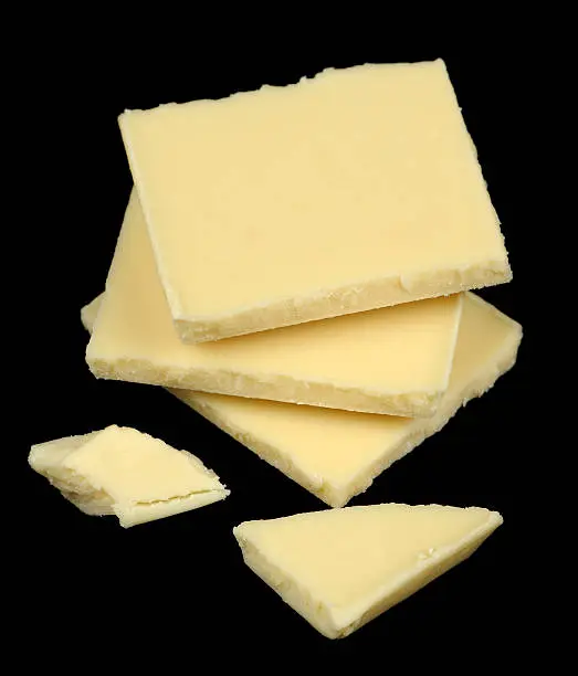 A few pieces of white chocolate on a black background