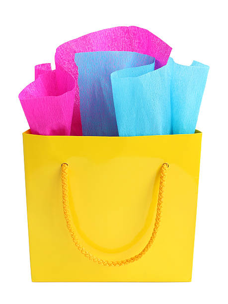 istock Yellow gift bag stuffed with pink and turquoise tissue paper 497021351