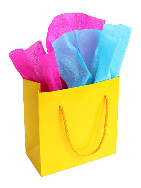 istock Yellow gift bag stuffed with pink and turquoise tissue paper 497021353