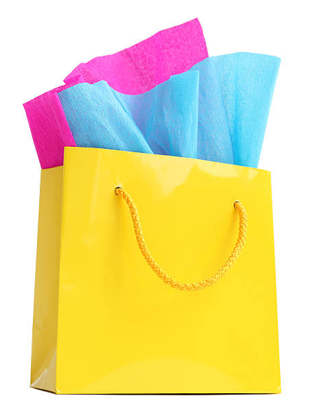 istock Yellow gift bag stuffed with pink and turquoise tissue paper 497021355