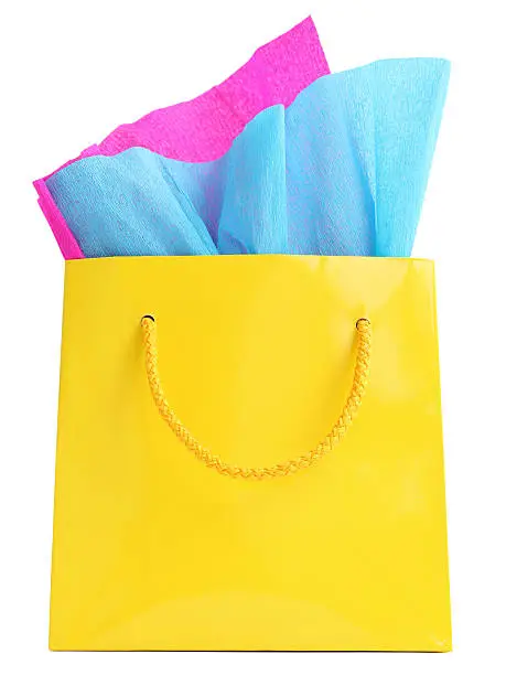 Photo of Yellow gift bag stuffed with pink and turquoise tissue paper