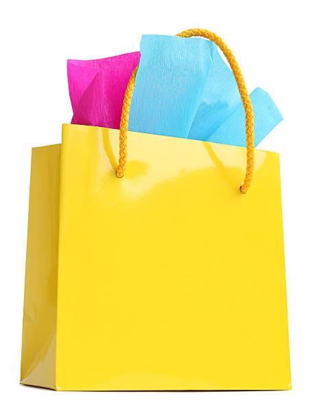 istock Yellow gift bag stuffed with pink and turquoise tissue paper 497021359