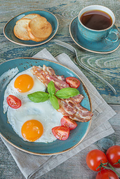 istock Fried eggs,  bacon, tomato, toast and a cup of coffee 497021750