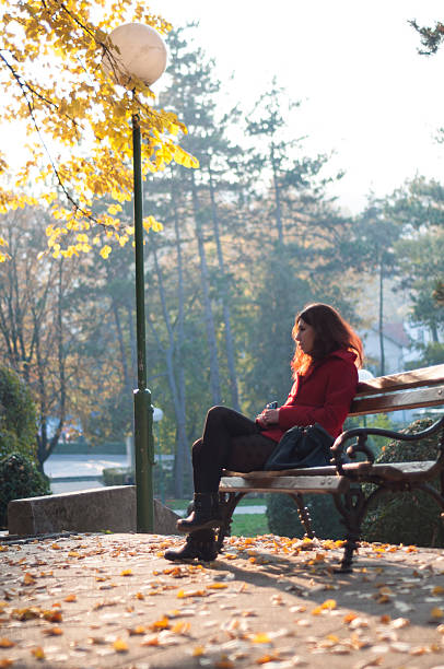istock Young woman sitting on the bench in autumn 497021880