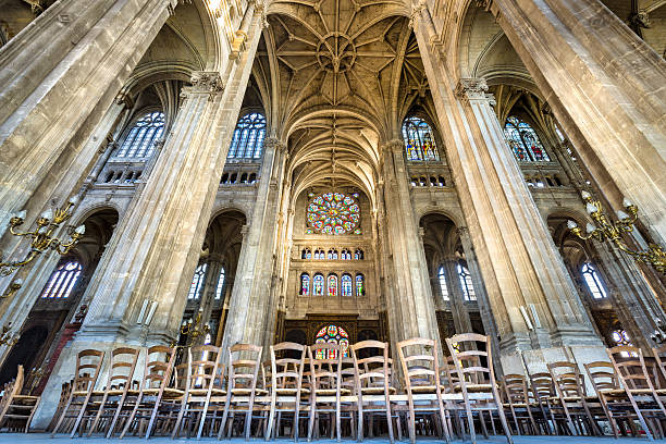 Transept with Vaulted Arches, Church of Saint Eustache, Paris, France Interior photo of the transept, Church of Saint Eustache, Paris, France. Rows of wooden chairs lead to the north rose window. The church, in Les Halles, 1st arrondissement, is an example of French Gothic architecture with vaulted arches. église saint eustache stock pictures, royalty-free photos & images