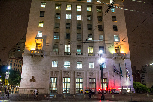 Sao Paulo, Brazil, November 12, 2015. People walking in front of  facade of Anhangabau Palace or Matarazzo Building at night. City Hall in Sao Paulo since 2004, located in Anhangabau Valley, near the Viaduct of Tea.