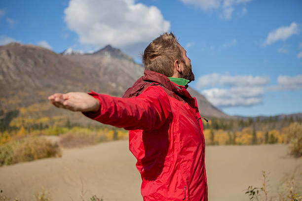 istock Man standing in desert arms outstretched for positive emotion 497027612
