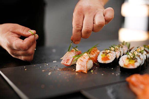istock Sushi master prepares futomaki 497028138