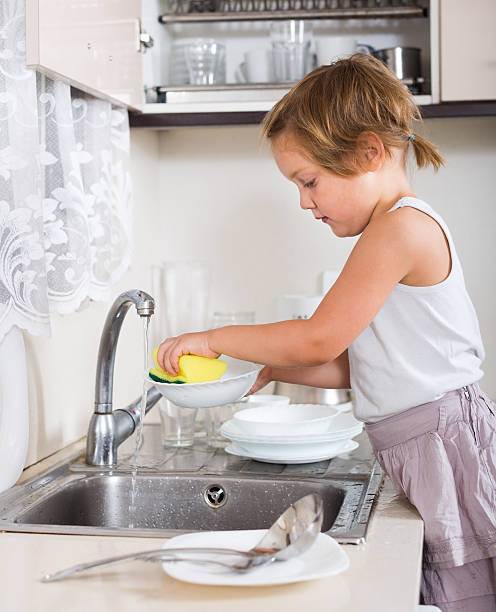 istock little girl washing dishes 497029780