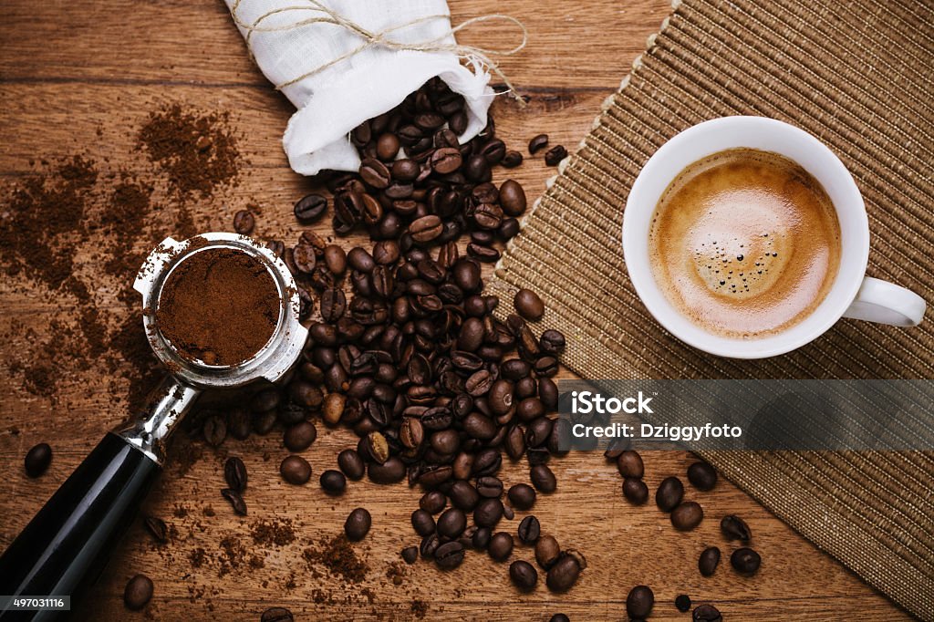 Espresso on a wooden table Espresso coffee overhead with spout and coffee beans on a wooden table Roasted Coffee Bean Stock Photo
