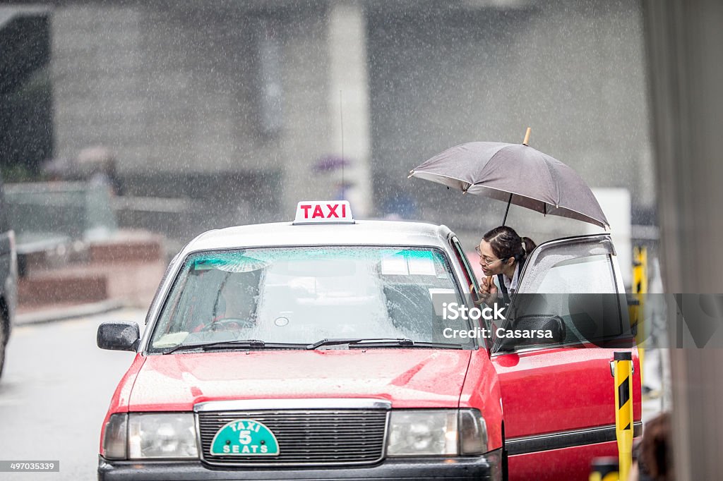 Asian Businesswoman calling a taxi Asian businesswoman portrait with umbrella calling a Taxi from the street on a rainy day Taxi Stock Photo