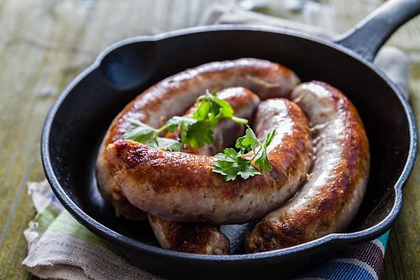 istock Grilled sausages on pan with herbs and spices 497035664