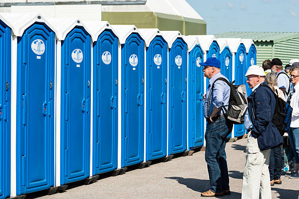 Kallinge, Sweden - June 01, 2014: Swedish Air Force air show 2014 at F 17 Wing. People queue outside temporary toilets with blue doors.
