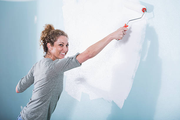 istock Woman painting wall 497040589
