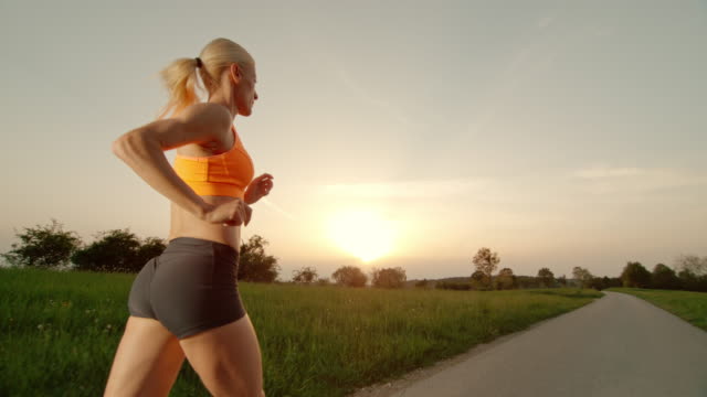 SLO MO TS Blonde woman running at sunset