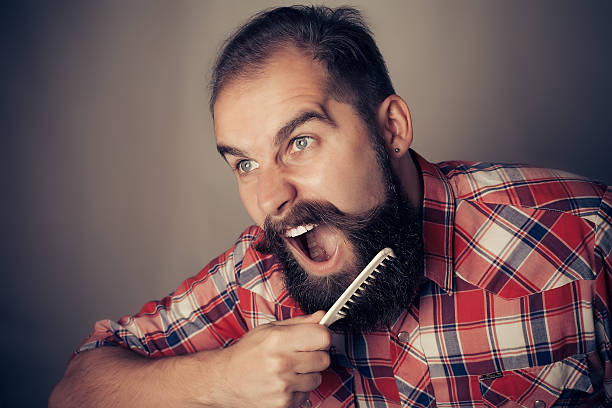 istock young man comb his beard and moustache on gray background 497055634