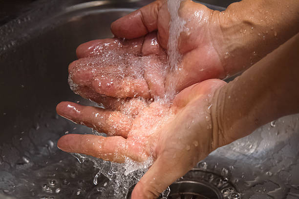 istock hands being washed under stream of  water from tap 497055750