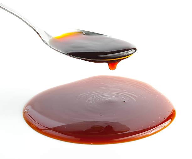 istock Pouring Soy Sauce on spoon isolated on white 497056668