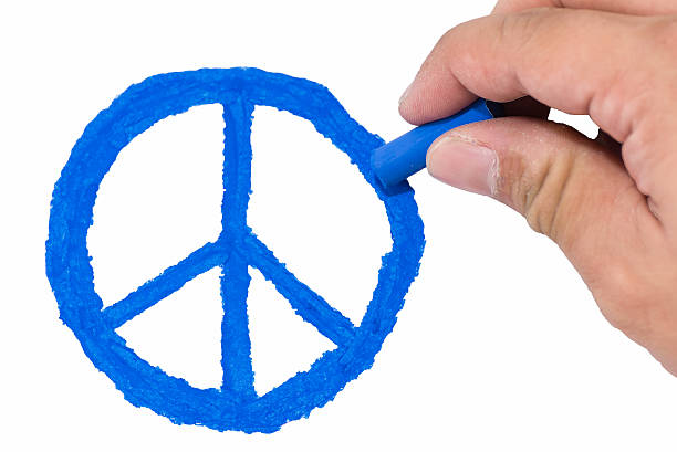yellow skin Asian man's right hand drawing blue color peace symbol isolated on white background