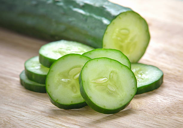 fatias de pepino fresco sobre fundo de madeira - cucumber - fotografias e filmes do acervo