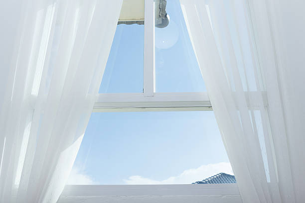 istock white curtain on the window with blue sky 497067304