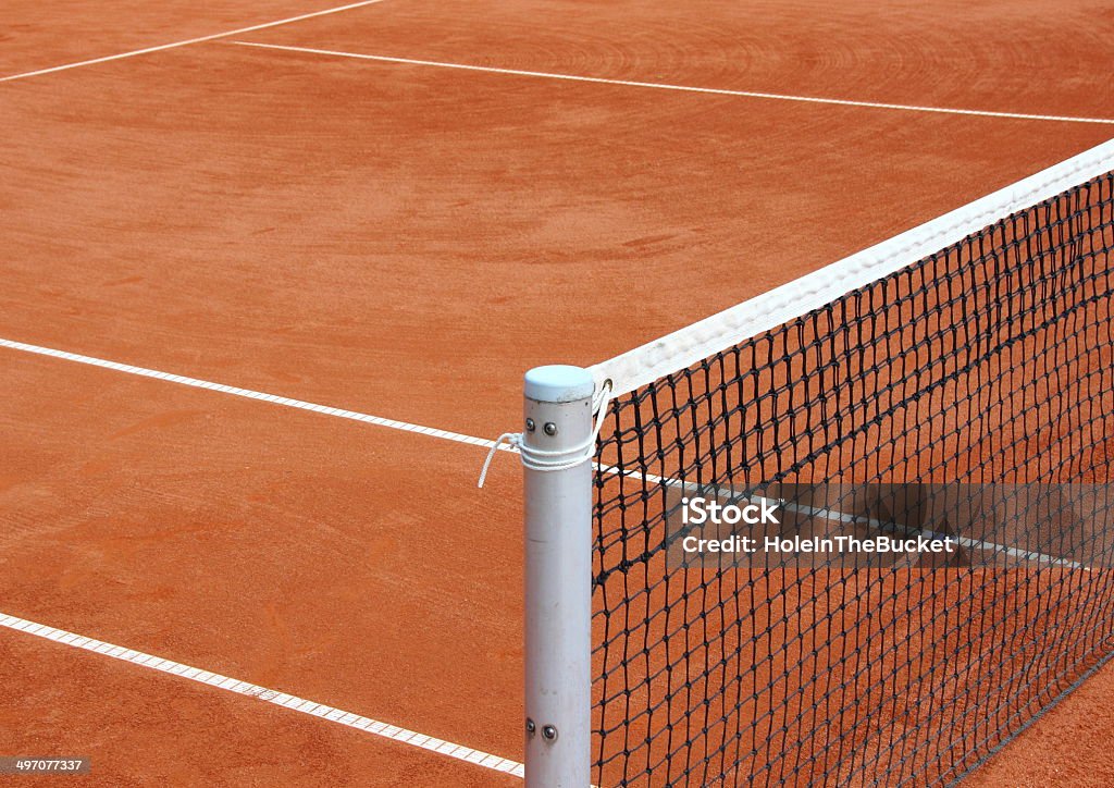 Tennis net at empty red gravel court Abandoned Stock Photo