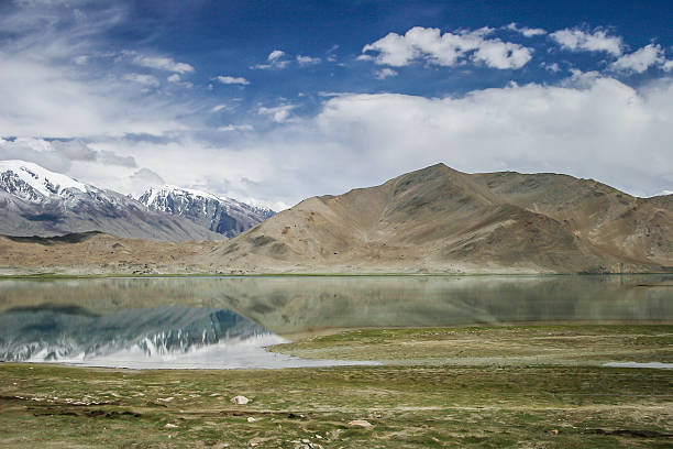 Karakul lake, Xinjiang, China Karakul lake, in  Xinjiang province of China lies on the Karakoram Highway linking Kashgar in China with Islamabad in Pakistan. It's in the Pamir mountain range. karakoram highway stock pictures, royalty-free photos & images