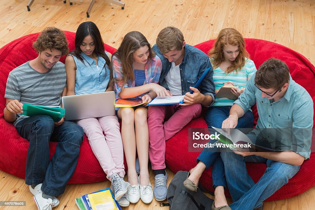 Students sitting on bean bags revising in common room Students sitting on bean bags revising in common room in college 20-29 Years Stock Photo