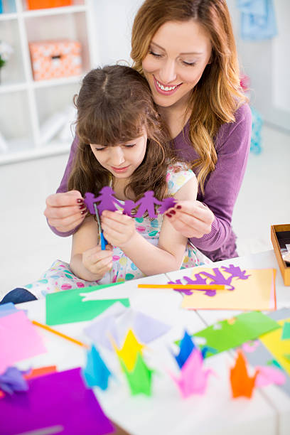istock Mother and daughter making origami. 497079357