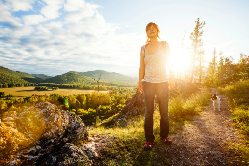 young beautiful woman trekking  in  mountains. Some lens flare