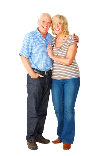 Full length portrait of loving senior couple standing together smiling on white background.