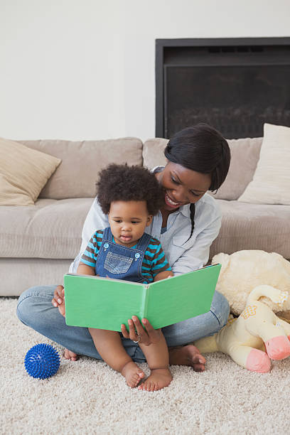 istock Afro mother with cute baby reading story book 497081571