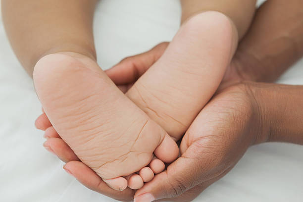 istock Mother holding baby's feet in bed 497081579