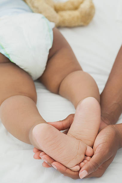 istock Mother holding baby's feet in bed 497081583