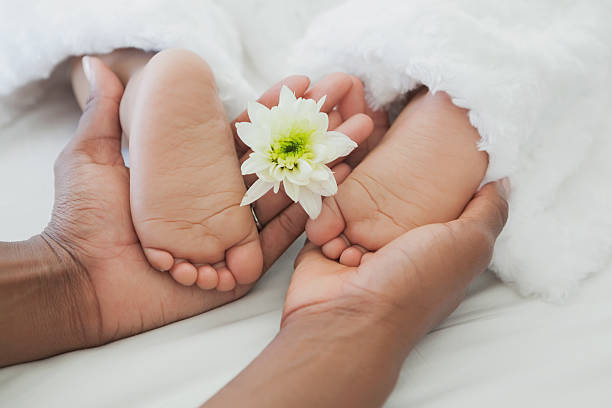 istock mother holding baby's feet in bed 497081613