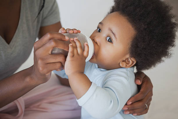 istock Mother feeding milk to baby boy from bottle 497081621