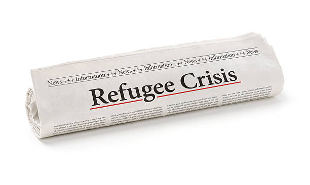 istock Rolled newspaper with the headline Refugee Crisis 497089506